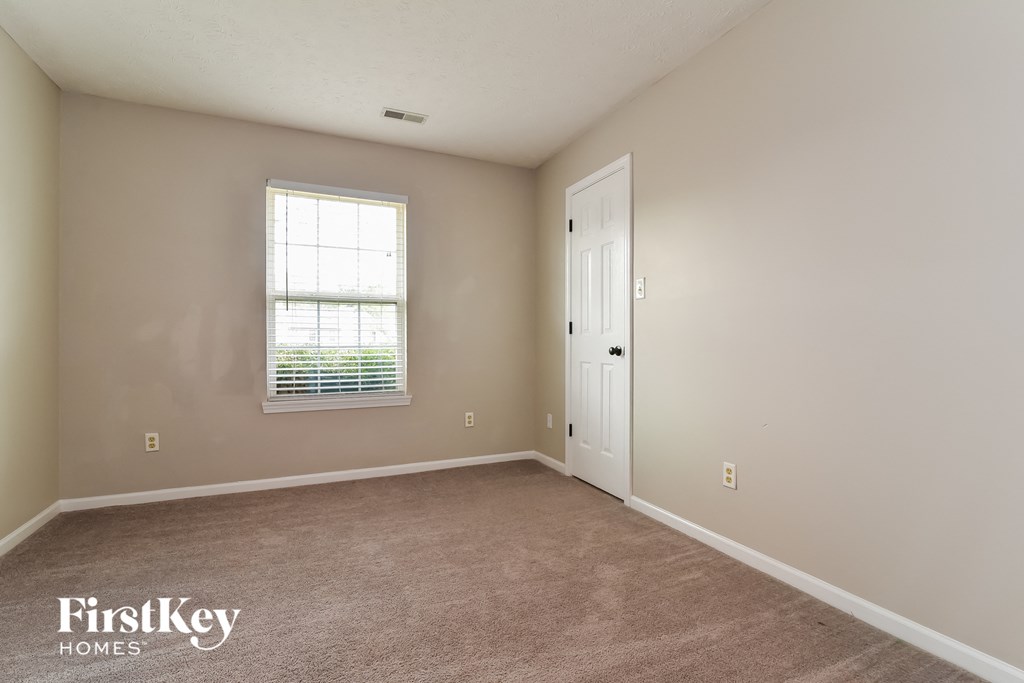 a bedroom with a white door and a window
