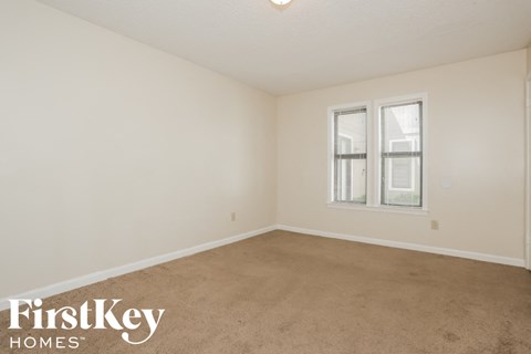 a bedroom with a carpeted floor and a window
