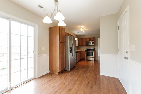 a renovated kitchen with wood floors and a stainless steel refrigerator