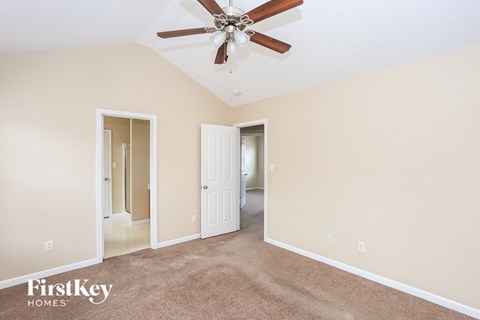 a living room with carpet and a ceiling fan