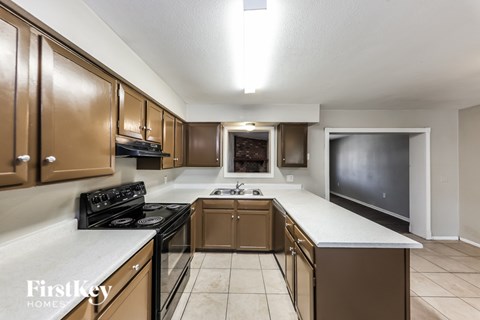 A kitchen with brown cabinets and a black stove top oven.