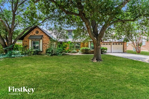 a small brick house with a tree in front of it