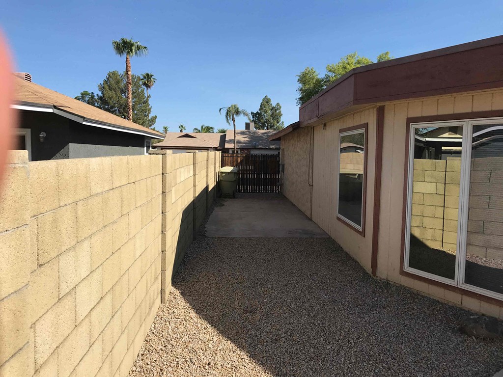 a walkway between two buildings with a fence