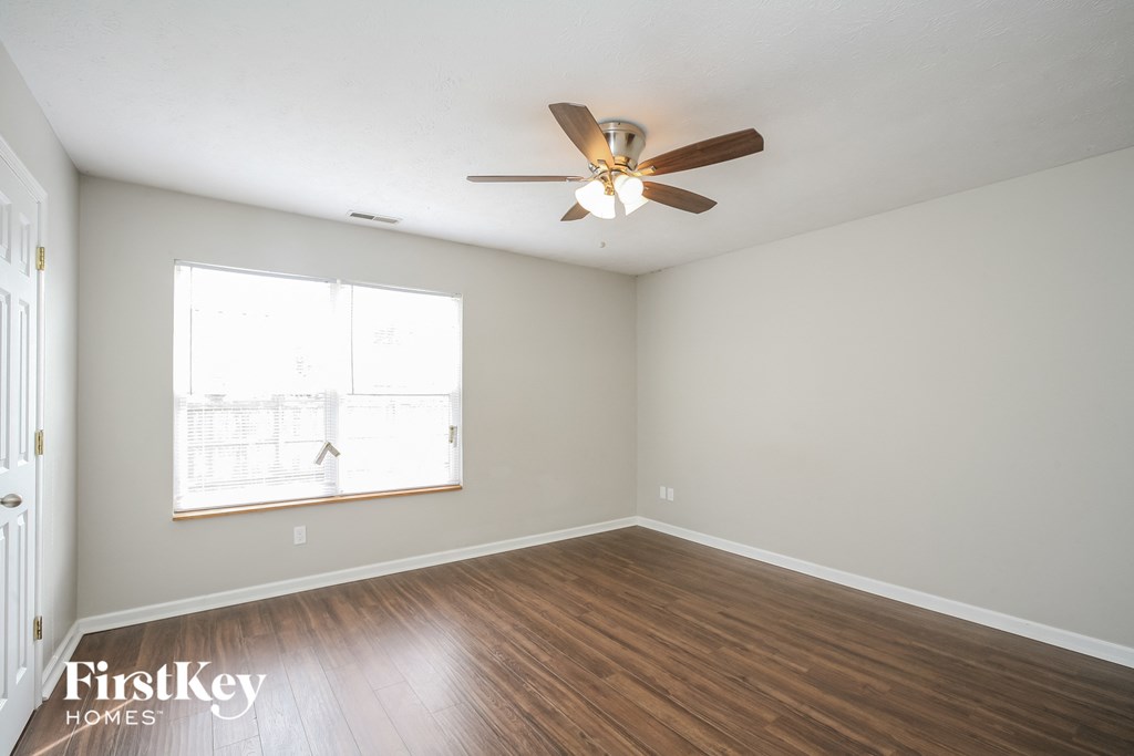 a living room with wood floors and a ceiling fan