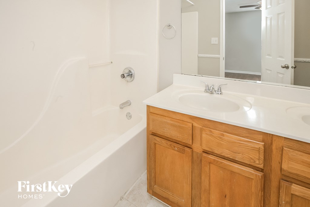 a bathroom with a sink and a tub and a mirror