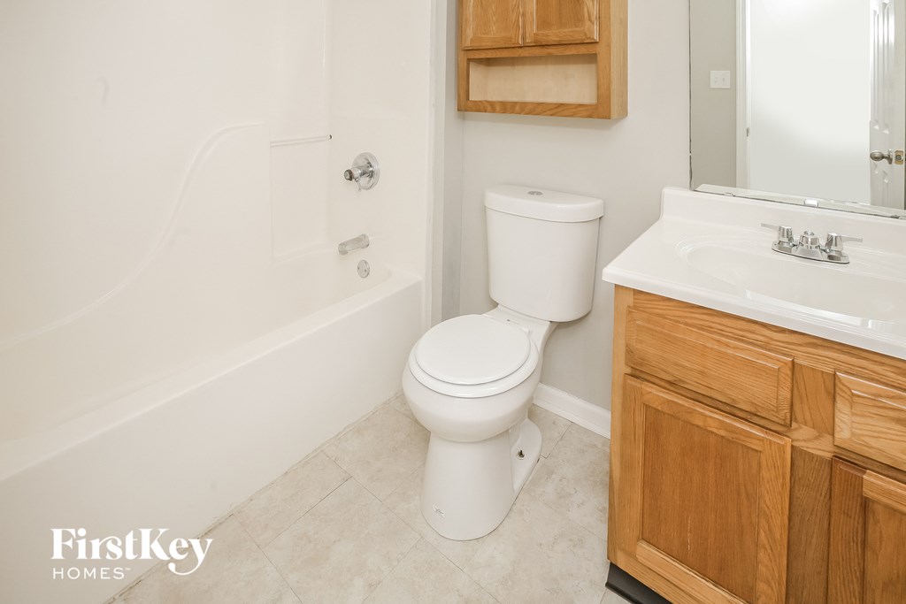 a bathroom with a toilet and a tub and a sink