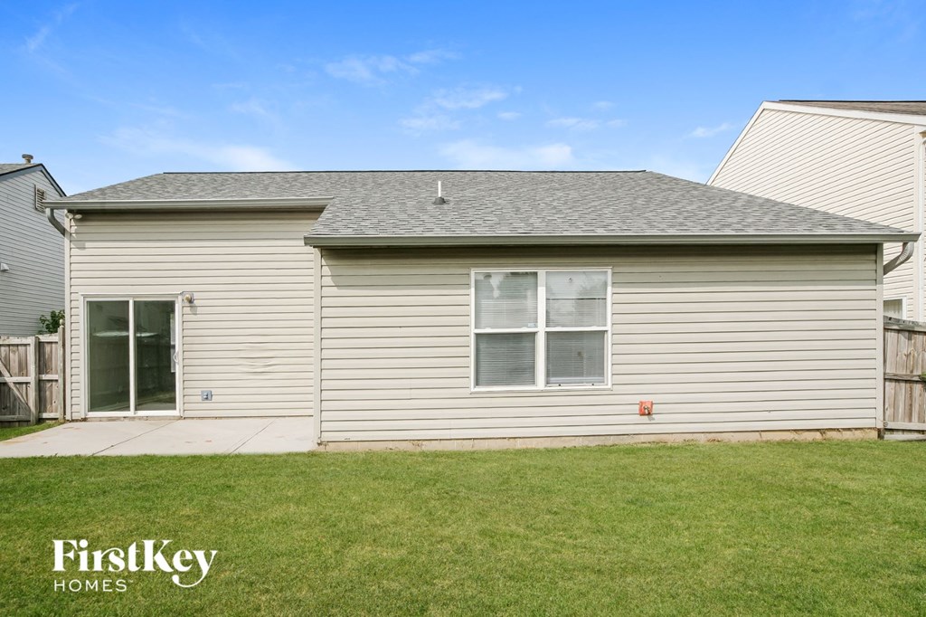 the front of a white house with a grassy yard