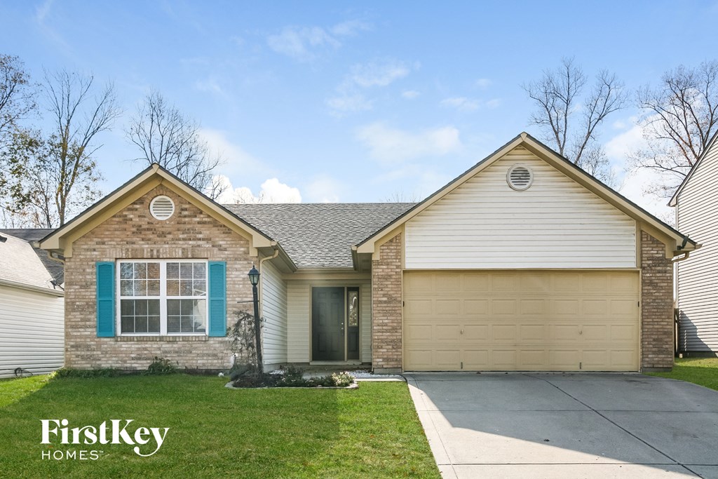 A house with a garage and a driveway in front of it.