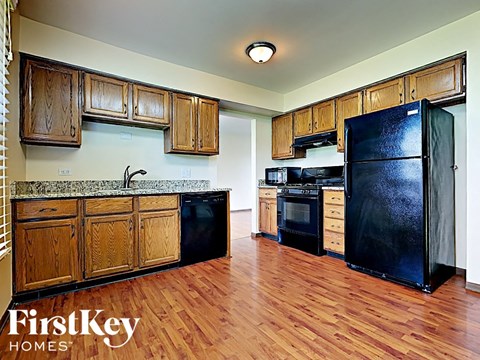 a kitchen with wood floors and black appliances
