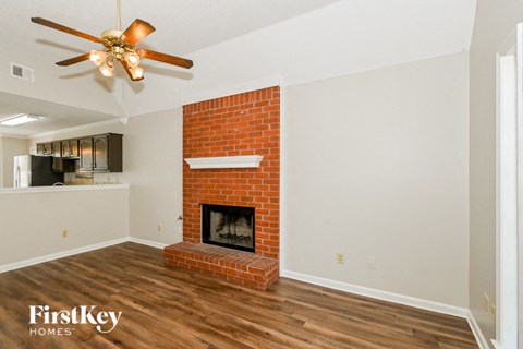 A room with a fireplace and a ceiling fan.
