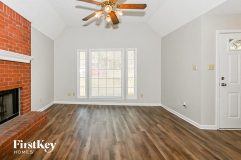 A room with a wooden floor and a ceiling fan.
