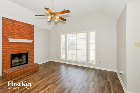 A room with a fireplace and a ceiling fan.