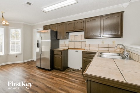 A kitchen with wooden cabinets and a stainless steel refrigerator.
