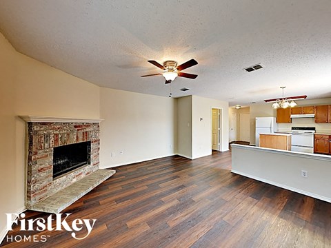 a living room with a fireplace and a ceiling fan