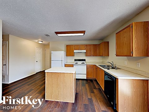 an empty kitchen with wood floors and white appliances