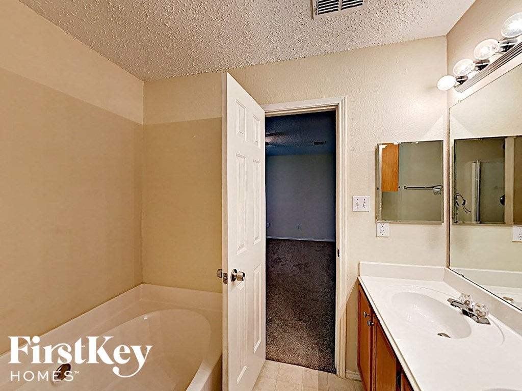 a bathroom with a sink and a tub and a mirror