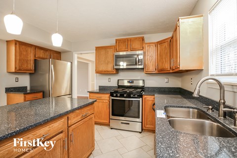 A kitchen with wooden cabinets and granite countertops.