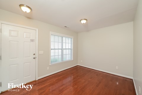 A room with a wooden floor and a white door.