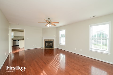 A spacious room with a fireplace and a ceiling fan.