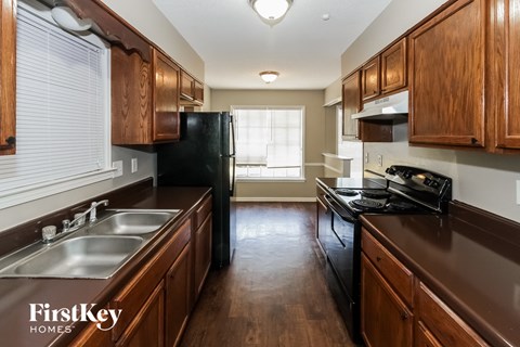 a kitchen with wooden cabinets and a black refrigerator and sink