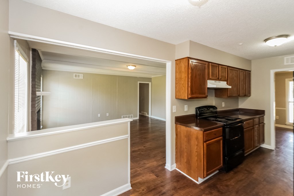 a kitchen and living room with wood floors and white walls