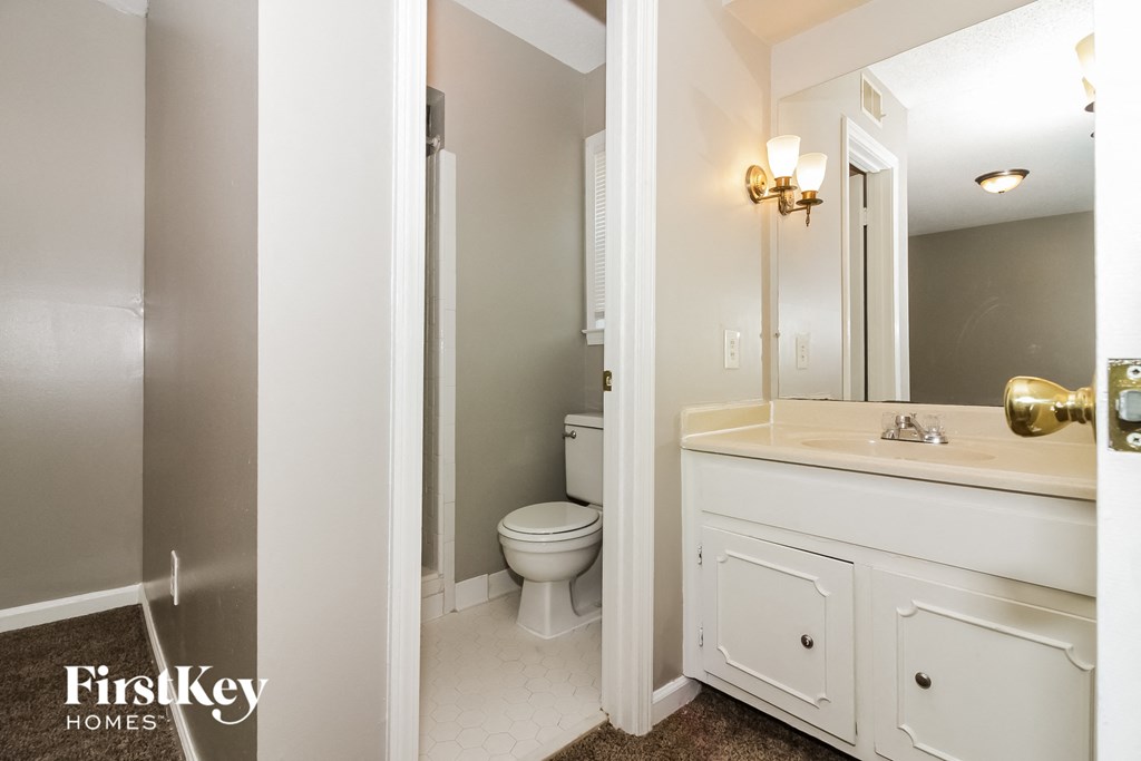 a bathroom with a toilet and a sink and a mirror