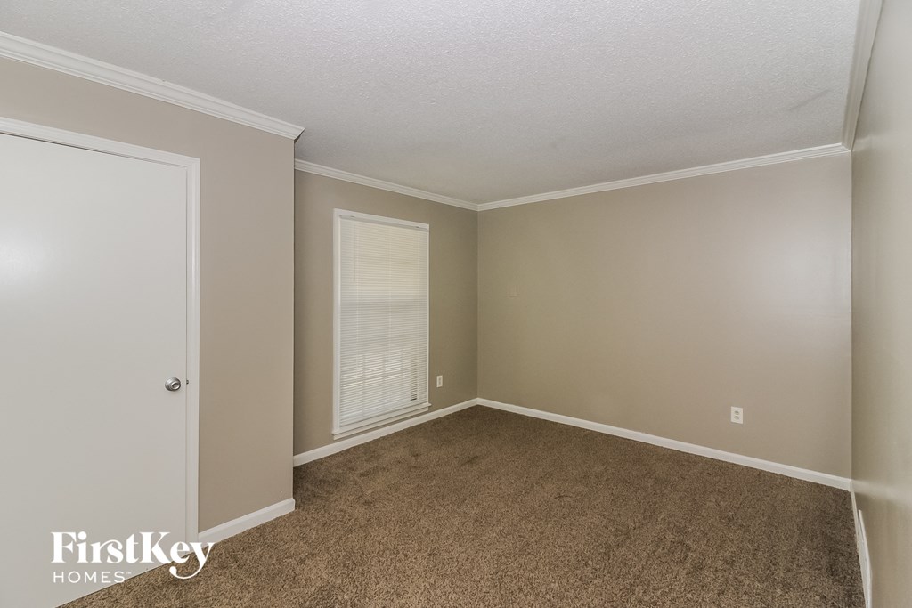 a bedroom with carpet and a door to a closet
