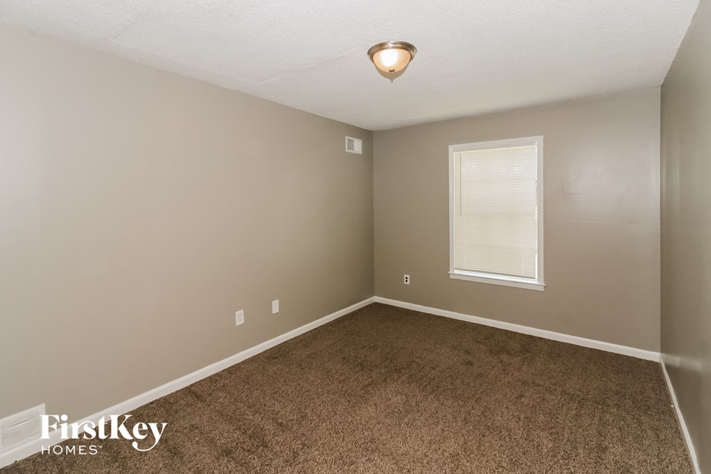 a bedroom with a carpeted floor and a window