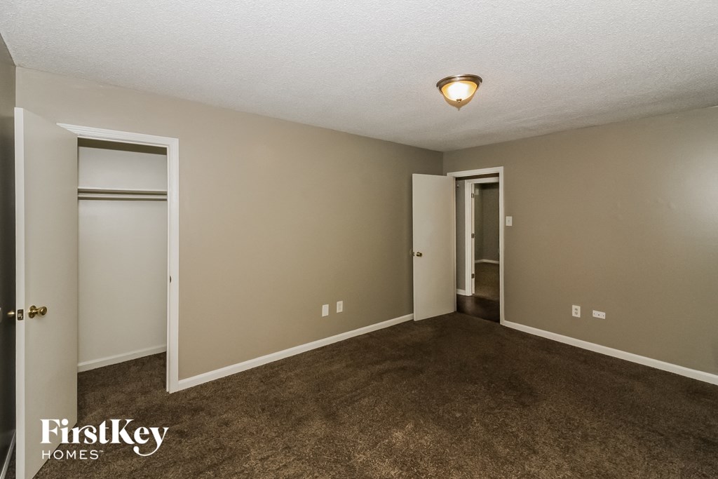 an empty living room with carpet and two closets