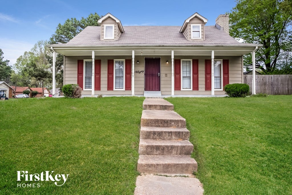 a house with red doors and a lawn and steps
