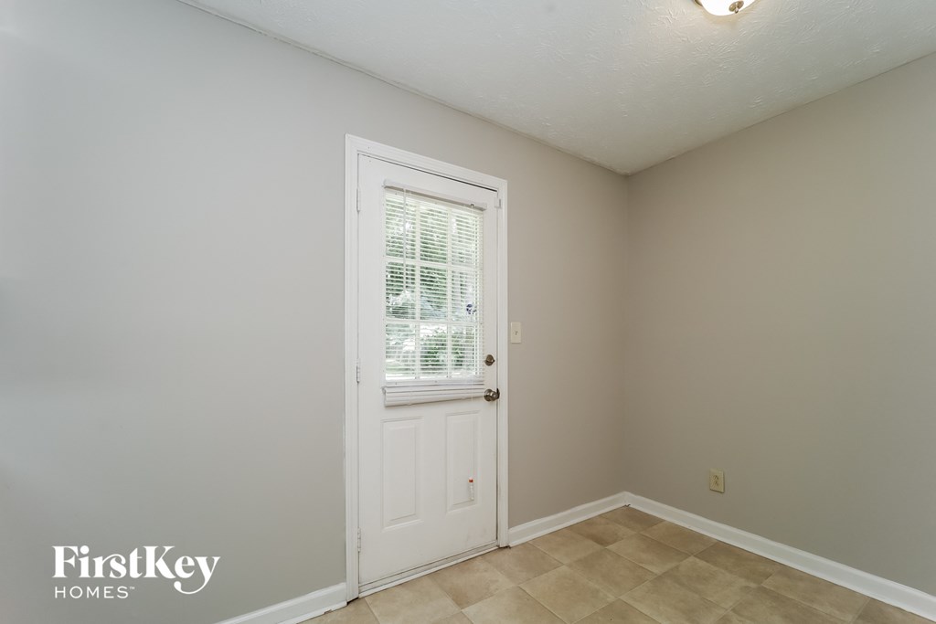 A room with a white door and a window with blinds.