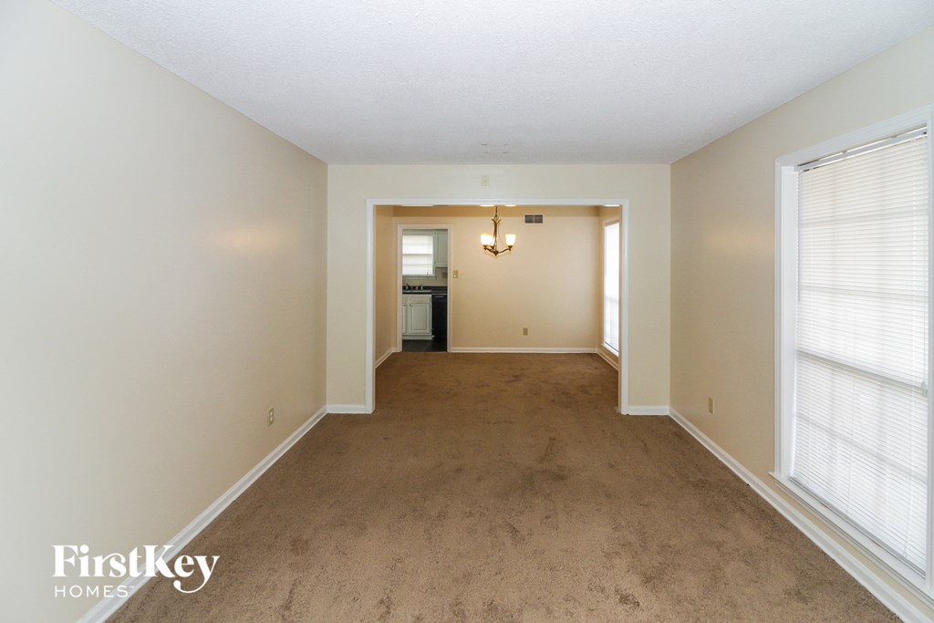 A room with a carpeted floor and a doorway leading to another room.