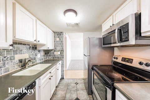 A kitchen with a stove top oven and a microwave.