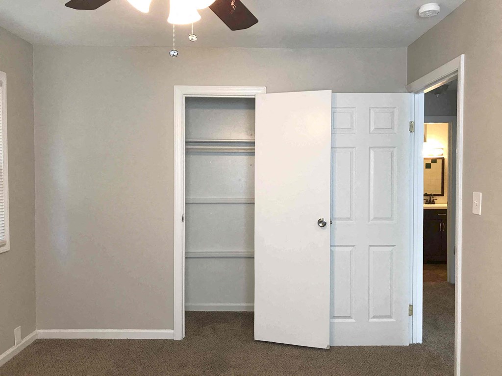 an empty room with a closet and a white door