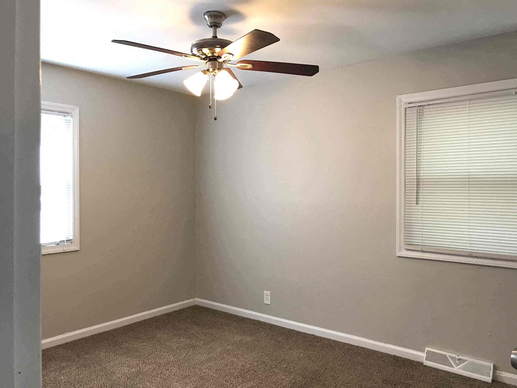 a bedroom with a ceiling fan and a window