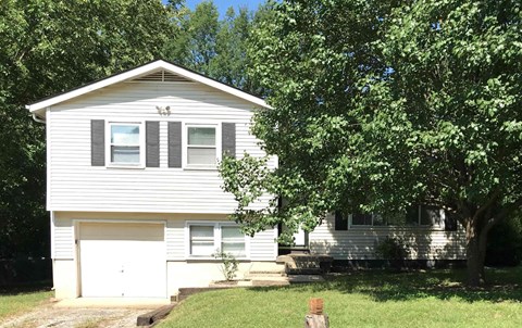 a white house with a tree in front of it