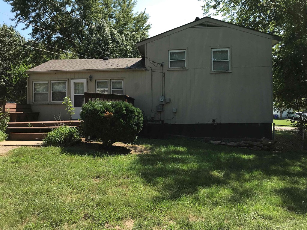 a small white house with a lawn in front of it