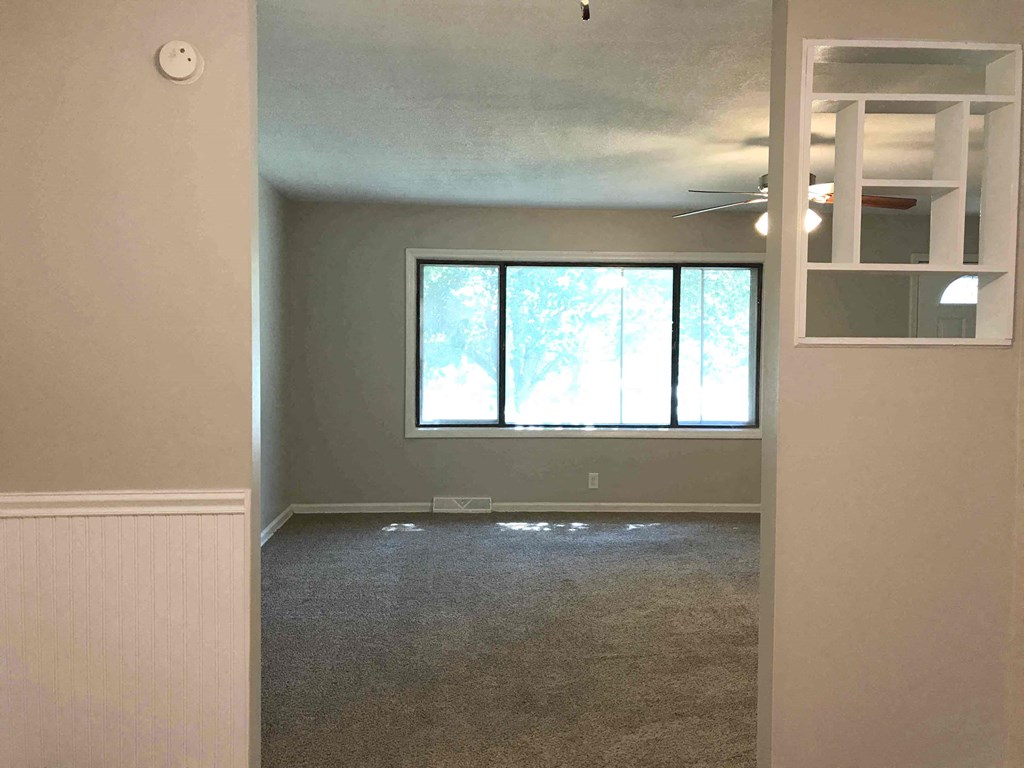 an empty living room with a large window