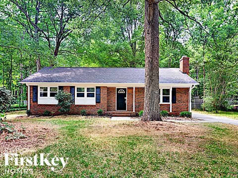 a small brick house with a tree in the yard