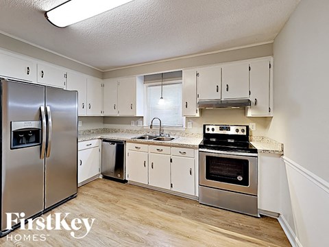 a kitchen with stainless steel appliances and white cabinets