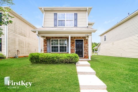 A house with a well-maintained lawn and a clear sky above.