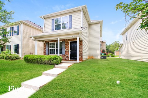 A house with a front yard and a white picket fence.