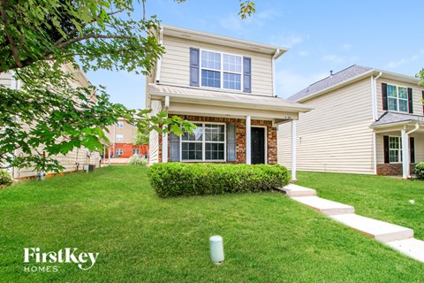 A house with a well-manicured lawn and a clear sky above.