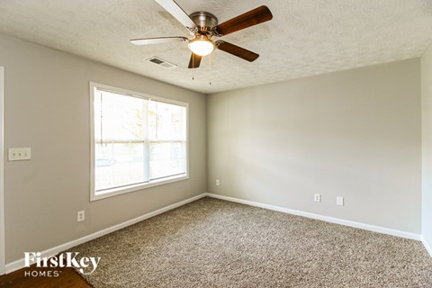 A room with a ceiling fan and a window.