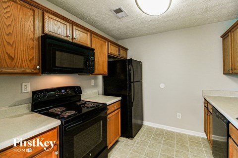 A kitchen with black appliances and wooden cabinets.