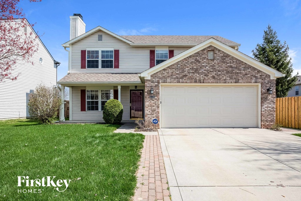 a home with a garage door and a lawn