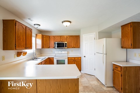 a kitchen with wooden cabinets and a white counter top