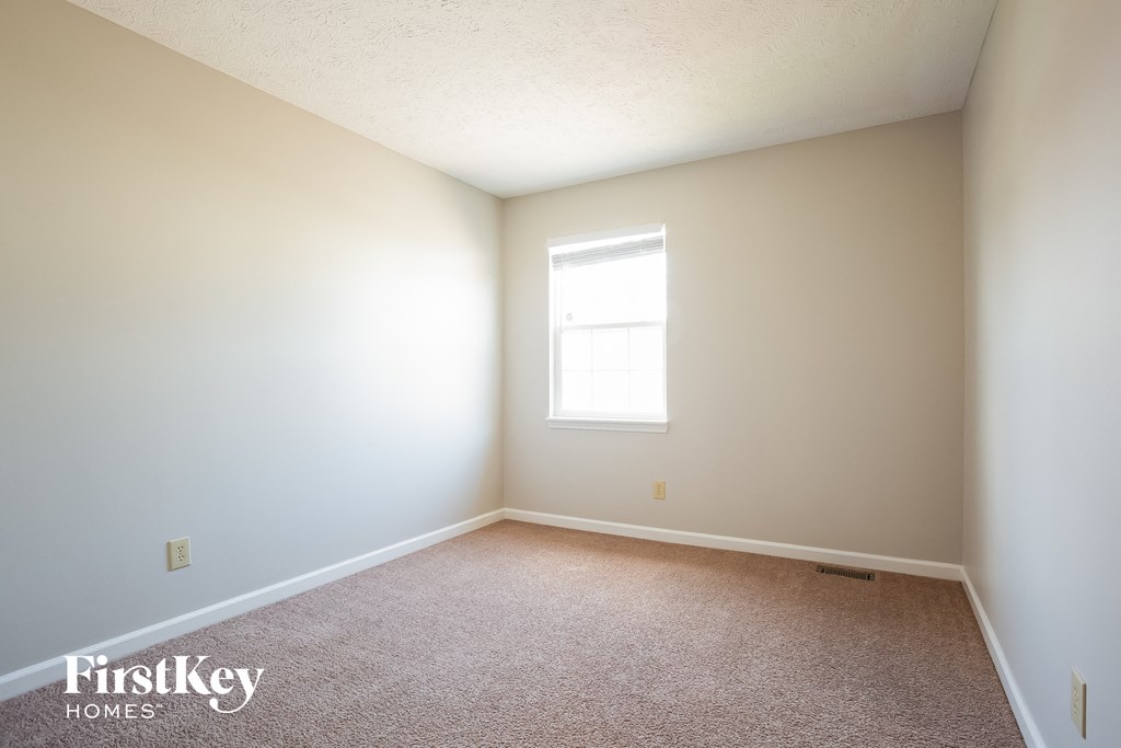 a white room with a window and a carpet