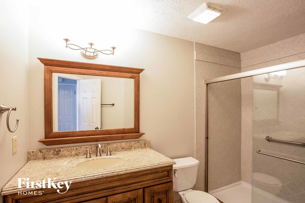 a bathroom with a sink and a shower and a mirror