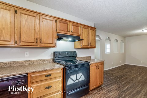 A kitchen with wooden cabinets and a black stove top oven.